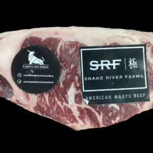 Corte marmoleado de Rib Eye American Wagyu Snake River Farms con etiquetas de marca sobre fondo negro.