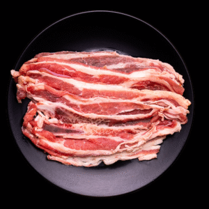 Rebanadas crudas de aguja norteña servidas en plato negro con rodajas de limón y ramas de romero.