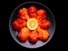 Alitas adobadas crudas sobre plato negro, listas para cocinar.