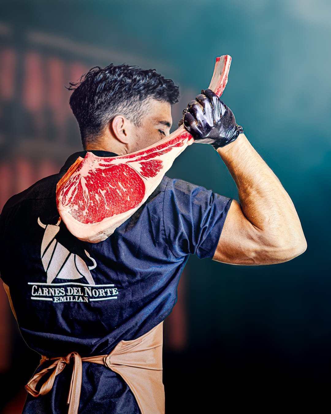 Carnicero prsesentando un corte con guantes  negros y tabla personalizada con el logo de Carnes del Norte Selecto