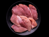 Maciza de cerdo en trozos sobre plato negro.