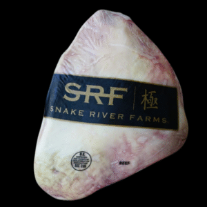 Pieza entera de picaña American Wagyu SRF empacada al alto vacío con etiqueta Snake River Farms en fondo negro.
